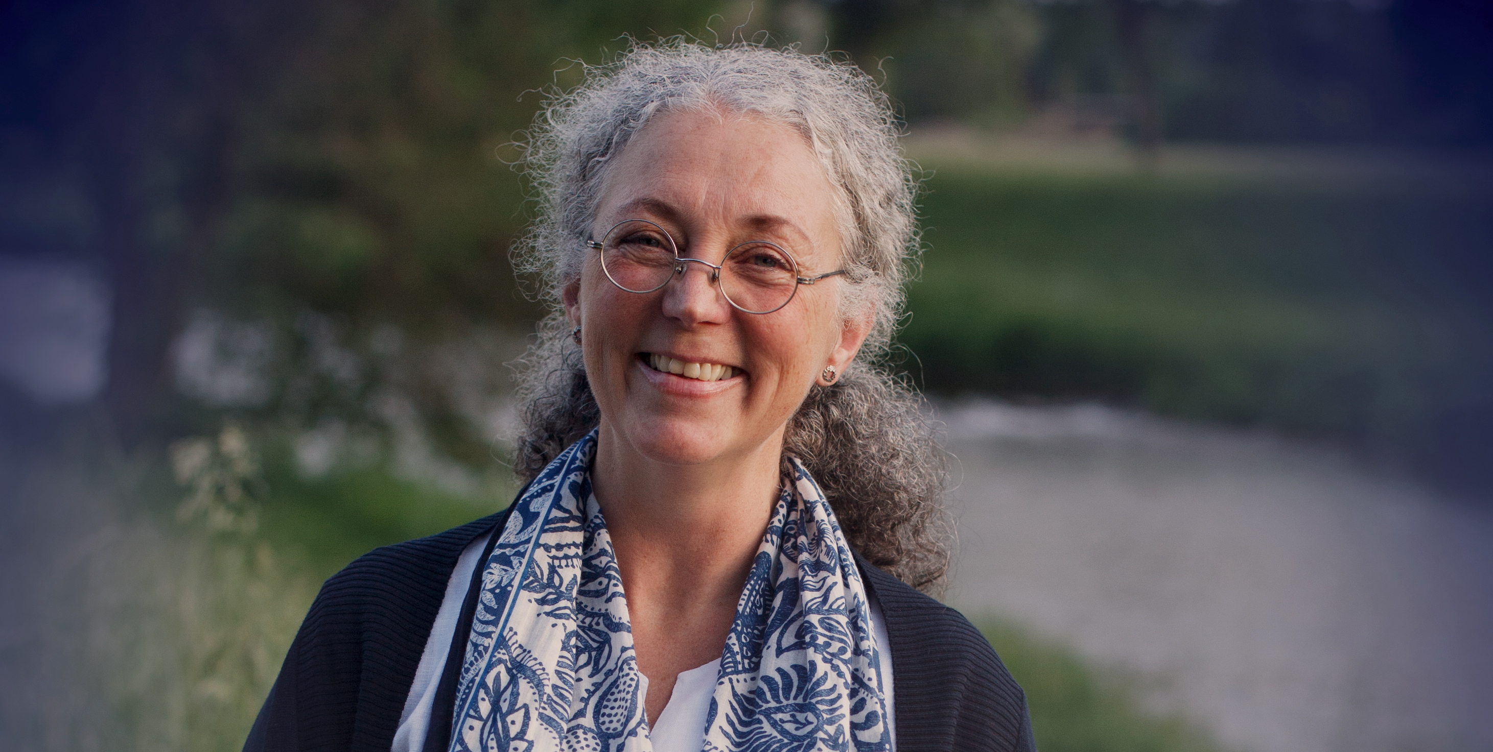 Steffi Kraft, lächelnd, vor einer Flusslandschaft