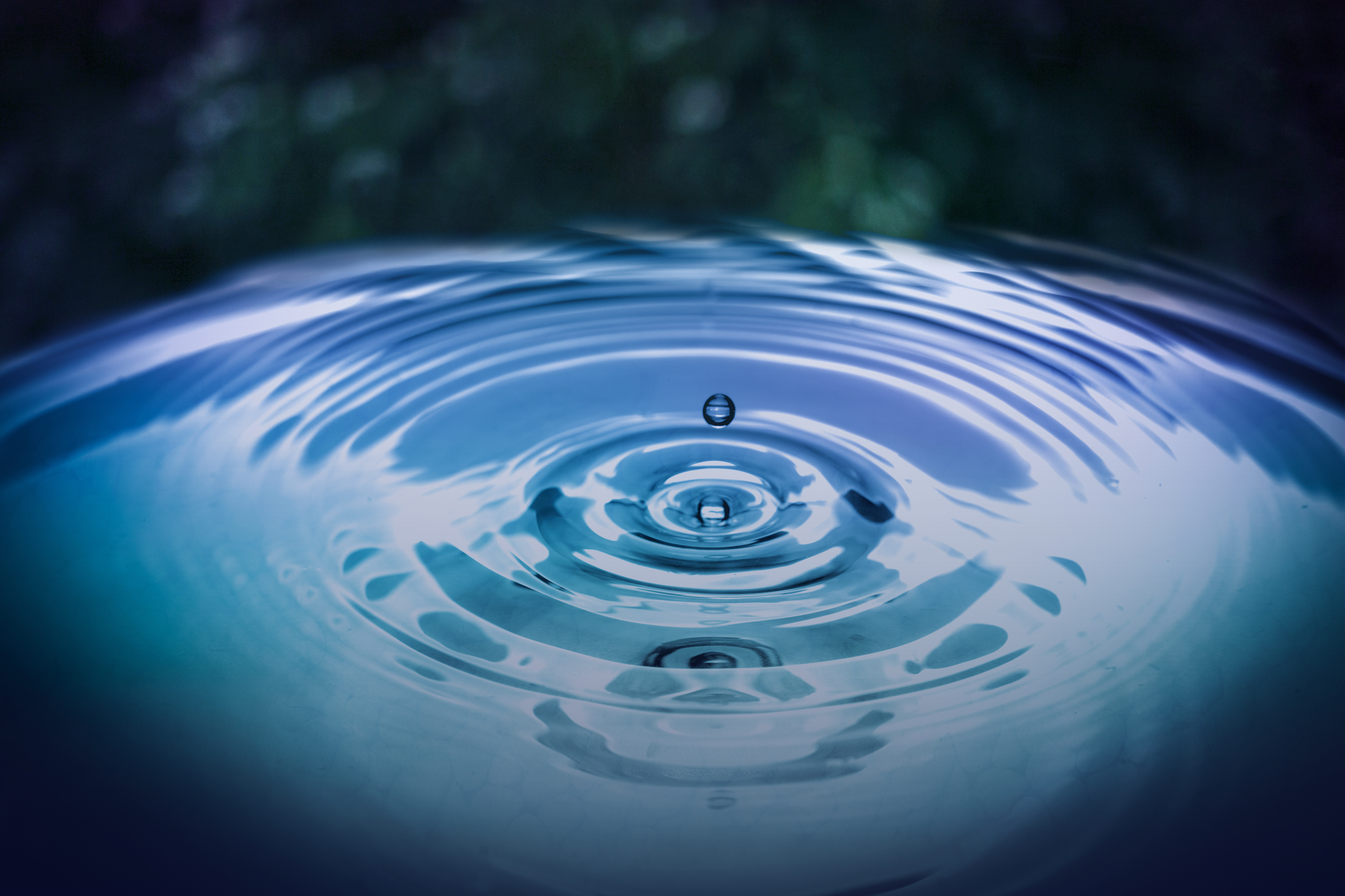 Ein Tropfen trifft auf die Wasseroberfläche